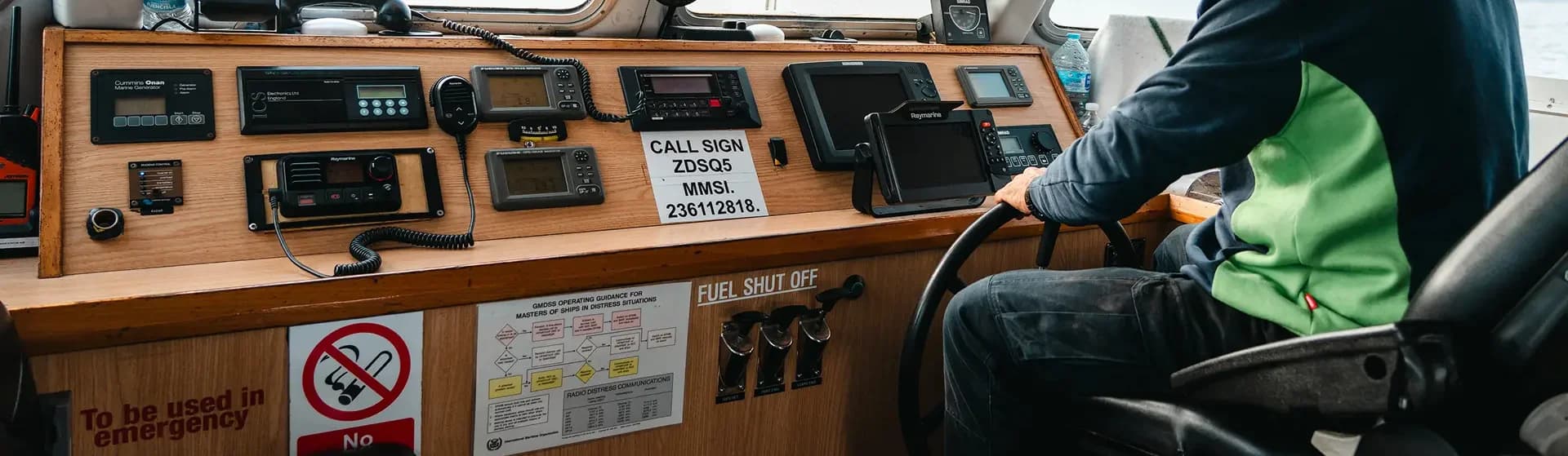 Hands operating the radar and navigation equipment in the wheelhouse